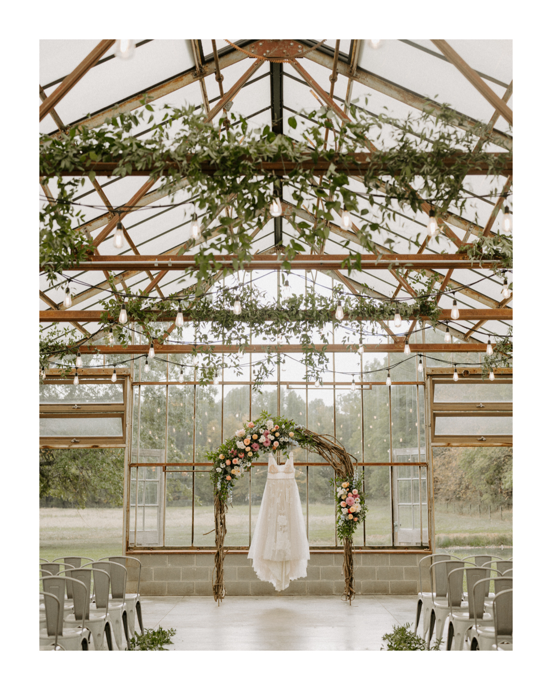 Wedding gown hanging in a greenhouse at Jorgensen Farms in Westerville, Ohio, captured by Ashley Wallace Photography. Elegant bridal dress displayed in a lush, natural setting with soft lighting.